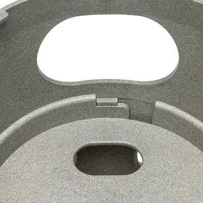Vista detallada de una carcasa metálica gris con aberturas ovaladas y bordes precisos, adecuada para aplicaciones técnicas.