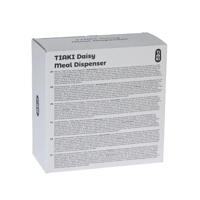 Verpackung des Tiaki Daisy Meal Dispenser mit mehrsprachiger Anleitung, darunter Deutsch, Englisch, Französisch, Niederländisch und Italienisch.