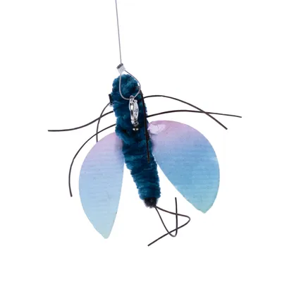 Giocattolo a forma di insetto con corpo blu, ali trasparenti e fili neri. Con clip in metallo per il fissaggio.
