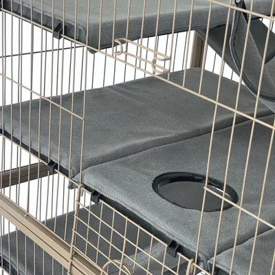 Višekatni kavez sa sivim, podstavljenim ležajima i okruglim otvorima za pristup između razina.