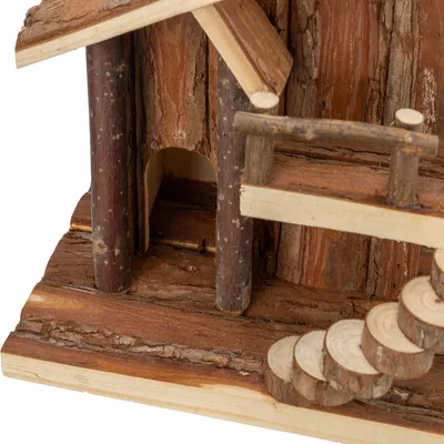 Vista detallada de una pequeña casa de madera con corteza, columnas de troncos redondos y una escalera de discos de madera.
