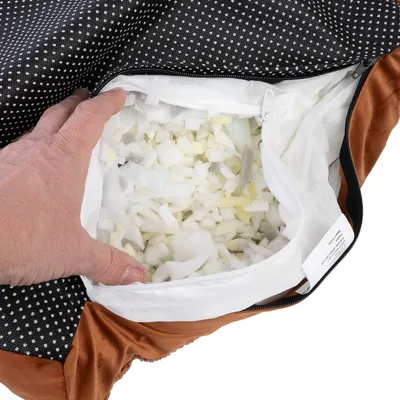 Vue rapprochée d’une housse de coussin pour animal ouverte, montrant la garniture intérieure en mousse découpée et une fermeture éclair. Main tenant le tissu pour exposer l’intérieur.
