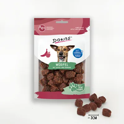 DOKAS Würfel mit Apfel und Banane, cubes ~2 cm, sachet refermable, 100% plant power, texte en anglais et allemand sur l’emballage, photo d’un chien sur le paquet.
