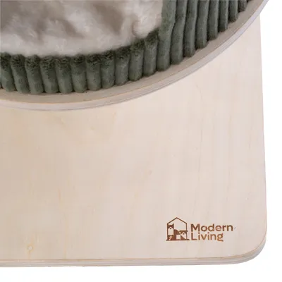 Tablero de madera con logotipo grabado 'Modern Living' y parte de un borde acolchado de tela verde visible.