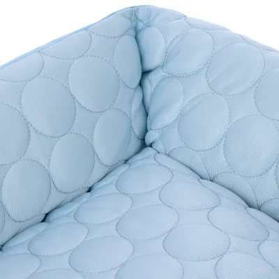 Zbliżenie na jasnoniebieski, pikowany materiał z okrągłym wzorem przeszyć.