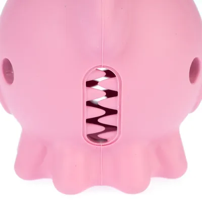 Jouet pour animal en caoutchouc rose, forme ronde avec ouverture centrale à dents en zigzag et trous latéraux visibles.