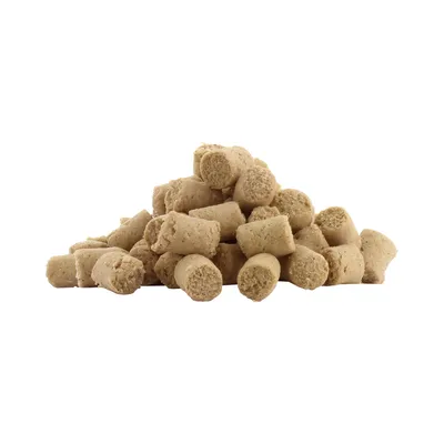 Haufen beige-farbener, zylindrischer Leckerlis oder Snacks ohne sichtbare Verpackung.