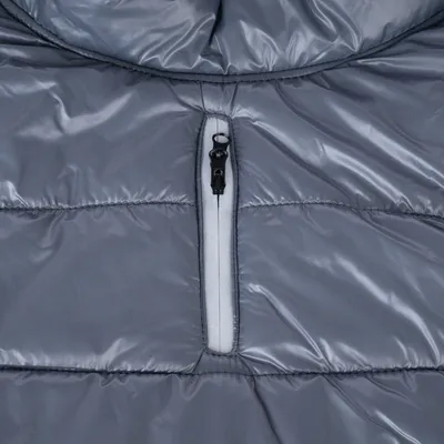 Détail d’un manteau matelassé gris avec fermeture éclair noire sur le devant, matière synthétique brillante visible.