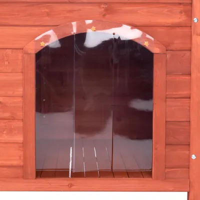Ingång till hundkoja i trä med genomskinlig plastdörr och små stjärndekorationer ovanför öppningen. Trägolv synligt innanför dörren. Ingång till hundkoja i trä med genomskinlig plastdörr och små stjärndekorationer ovanför öppningen. Trägolv synligt innanför dörren.