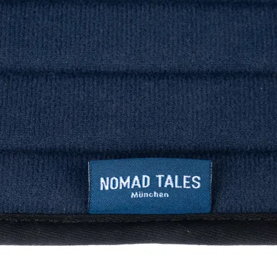 Nomad Tales München. Etykieta na ciemnoniebieskiej tkaninie.