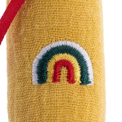 Gelber Stoff mit gesticktem Regenbogen in Rot, Gelb, Grün und Weiss. Detailaufnahme eines Designs.