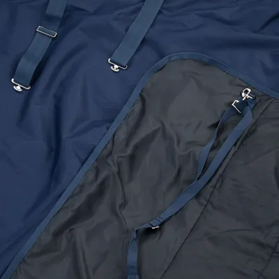 Donkerblauwe hondendeken met riemen en metalen clips, waterafstotend materiaal zichtbaar.