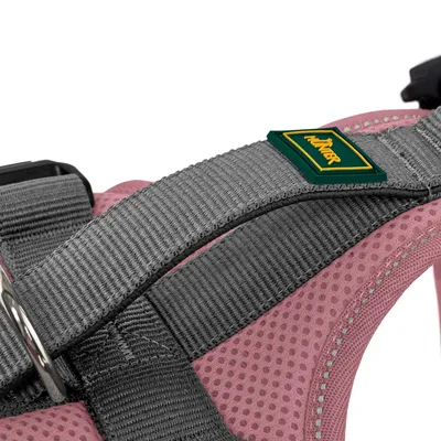 Detailaufnahme eines rosa und grauen Hundegeschirrs mit Hunter-Logo, gepolstertem Material und Metallring.