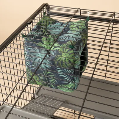 Hangmat met groen bladmotief, bevestigd aan metalen kooi met haken. Geschikt voor kleine dieren.