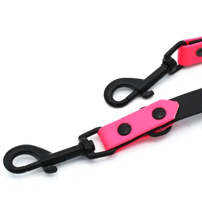 Schwarzer Karabinerhaken mit pinkfarbenem Kunstlederband und schwarzen Nieten, geeignet für Befestigung an Leinen oder Zubehör.