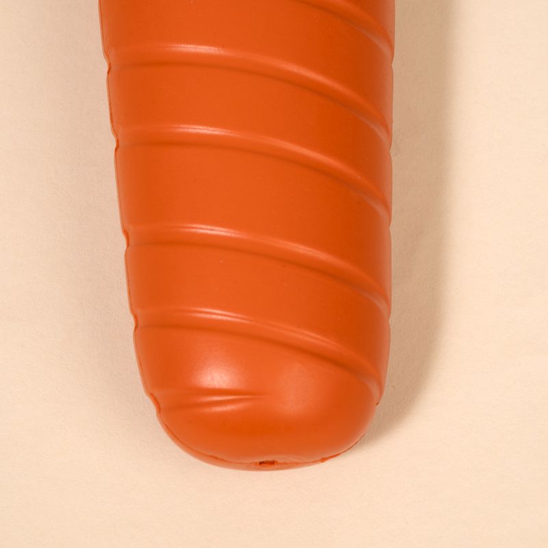 Orangefarbenes, geripptes Kunststoffspielzeug in Karottenform.