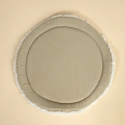Ronde, beige gevoerde mat met zachte rand van imitatiebont. Geschikt als onderlegger of kussen voor huisdieren.