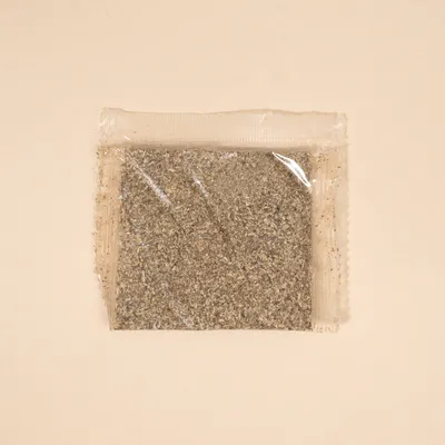 Transparenter Beutel mit gemahlenem Kräutermix, geeignet für Tierfutter oder Ergänzungsmittel.