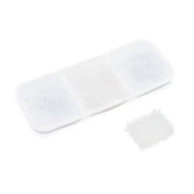 Filtre rectangulaire blanc en tissu non tissé avec compartiments visibles, accompagné d’un petit tampon filtrant blanc séparé. Aucun texte ou marque visible.