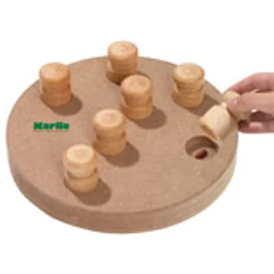Rond houten intelligentiespel met zeven cilinders, merknaam Karlie zichtbaar. Hand tilt een cilinder op om een opening in het spel te onthullen.