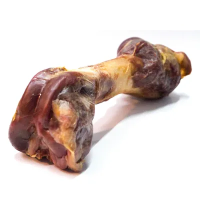 Hueso seco de carne con acentos marrones y rojos, apto como snack para masticar.