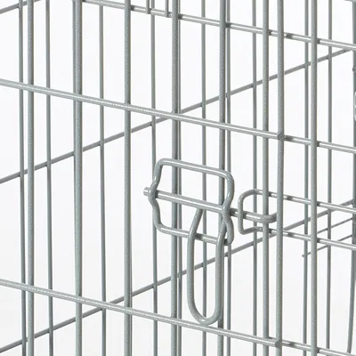 Detailansicht eines Metallkäfigs mit Gitterwänden und einem Verschlussmechanismus.