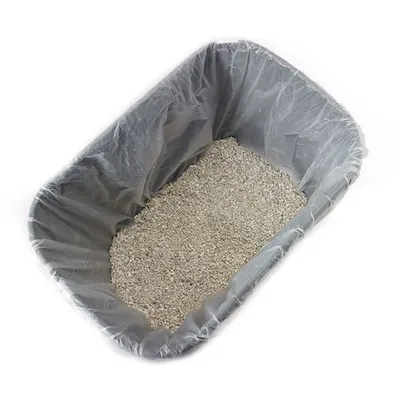 Bandeja rectangular con bolsa de plástico gris y arena para gatos en su interior, vista desde arriba.