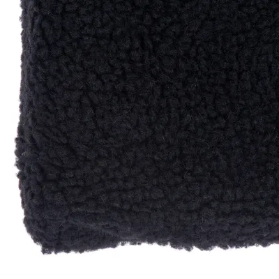 Gros plan sur une surface en tissu noir à texture bouclée, type polaire ou laine synthétique. Aucun texte ni marque visible.