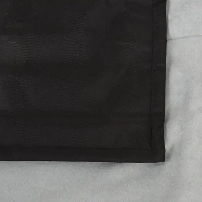 Černá tkanina s jemnou texturou, obdélníkový tvar na šedém pozadí.