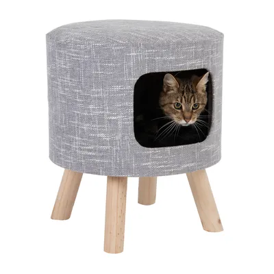Grauer Hocker mit Holzbeinen und integriertem Katzenversteck. Katze schaut aus der Öffnung heraus.