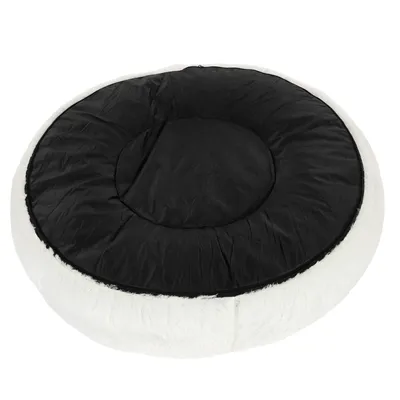 Rond, wit huisdierenbed met zwart stoffen ligvlak. Buitenkant met zachte vachtlook.