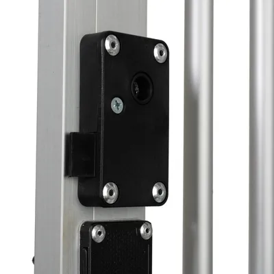 Dettaglio di chiusura in plastica nera con viti su struttura in metallo argentato, parte di una griglia o cancello per animali.