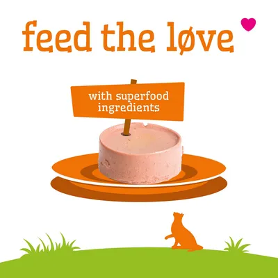 Text: ge kärleken näring. Med superfood-ingredienser. Avbildad är en rund foderbit på en tallrik. Text: ge kärleken näring. Med superfood-ingredienser. Avbildad är en rund foderbit på en tallrik.