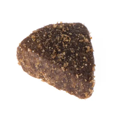 Primo piano di un croccantino triangolare marrone con consistenza granulosa.