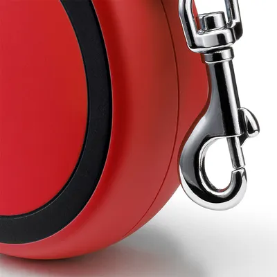 Dettaglio di guinzaglio avvolgibile rosso con moschettone in metallo visibile. Nessun marchio o testo identificativo presente.