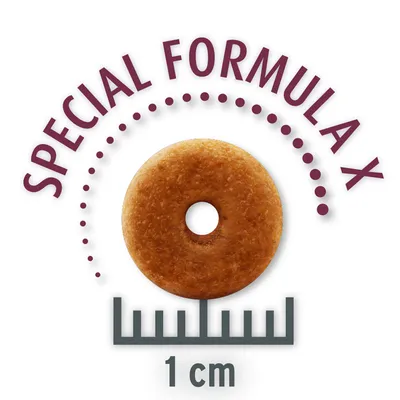 Rund foderbit med hål, texten SPECIAL FORMULA X ovanför och linjal under som visar diameter 1 cm.
