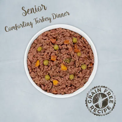 Texte visible : Senior Comforting Turkey Dinner, Grain Free Recipe. Bol de pâtée avec morceaux de carotte et petits pois verts.