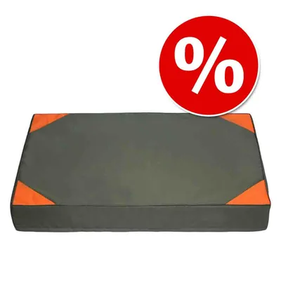 Colchón rectangular para mascotas en color gris con esquinas naranjas. Símbolo de porcentaje en círculo rojo indica oferta o descuento.