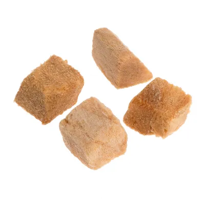 Neljä pakastekuivattua lihakuutiota beige-ruskeassa värissä, näkyvissä ilman pakkausta.