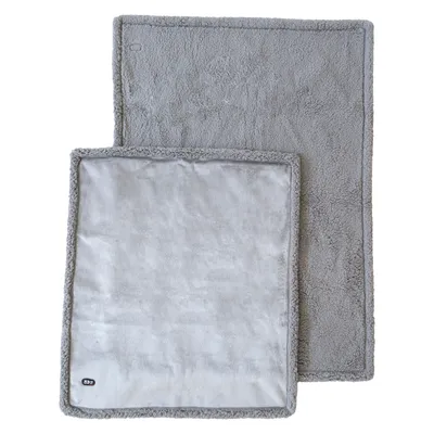 Deux tapis rectangulaires gris en tissu, l’un posé partiellement sur l’autre, bords cousus visibles, étiquette « XS » sur le coin du plus petit tapis.