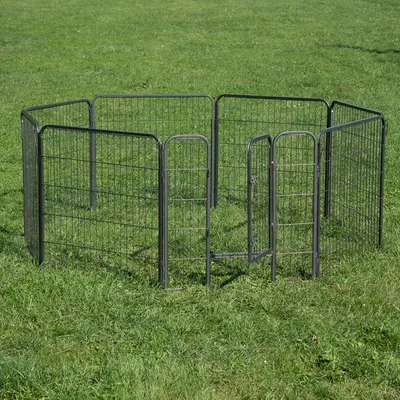 Kovový výbeh s ôsmimi mrežovými prvkami a jednými dverami, postavený na zelenej lúke.