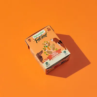 Box labelled 'Feel Good' turkey and chicken with rice and carrots, 390g. Shows illustrations of ingredients and animals. Marked as made in UK and suitable for adult pets.