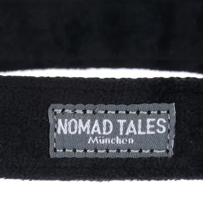Nomad Tales München. Metka marki na czarnym materiale.