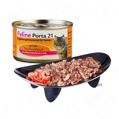 Konzerva Feline Porta 21 pre mačky, celé tuniakové mäso s pravým krabím mäsom v želé, nemecký text na obale. Obsah konzervy naservírovaný na čiernej miske.