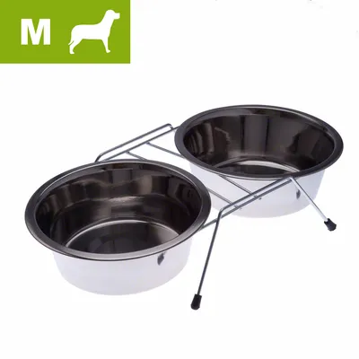 Kaksi ruostumattomasta teräksestä valmistettua koiran ruokakuppia metallitelineessä, vasemmassa yläkulmassa vihreä laatikko, jossa M-koko ja koiran siluetti.