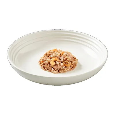 Порция консервирана храна за домашни любимци с парчета месо и скариди, сервирана в бяла купа.