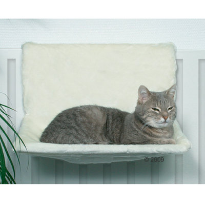 Grå katt ligger på vit fönsterbräda med mjuk dyna, monterad på element. Dynan ser ut att vara av tygmaterial.