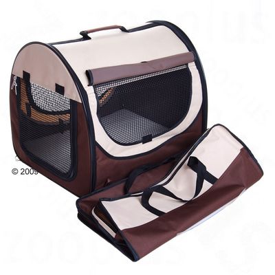 Niche de transport pliable en tissu beige et marron avec fenêtres en maille noire, poignée sur le dessus et ouverture zippée à l’avant. Sac assorti posé devant la niche.