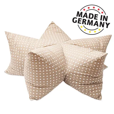 Deux coussins beiges à pois blancs, texte visible : MADE IN GERMANY