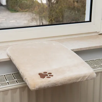 Béžová podložka na parapet s mäkkým povrchom a vyšitým motívom labky, vhodná na radiátory pod parapetom.